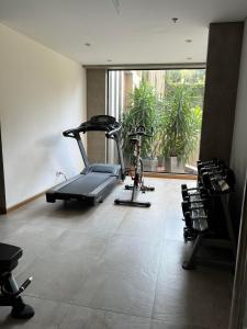 a room with a gym with a treadmill and chairs at Gomez de castro apartments in Asunción