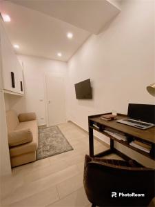 a living room with a desk and a chair and a laptop at Fifi Home in Pozzuoli