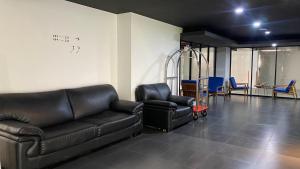 a living room with a leather couch and chairs at JW NAUNGAN COLIVING in Solo