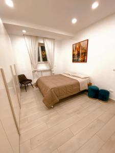 a bedroom with a large bed and a chair at Fifi Home in Pozzuoli