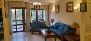 a living room with two blue couches and a table at Maadi International Center Apartments in Cairo