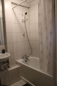 a white bathroom with a tub and a sink at Cosy 1 Bed Flat in Central London with View of Shard in London +8 photos