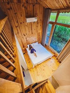 an overhead view of a person laying on a bed in a tree house at Chien's Lodge Du Gia in Làng Cac