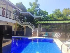 a swimming pool in front of a house with a staircase at Alona WhiteHouses Resort in Panglao Island