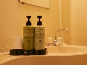 two bottles ofodorizers sitting on top of a bathroom sink at Hotel SIMIZU in Tokamachi