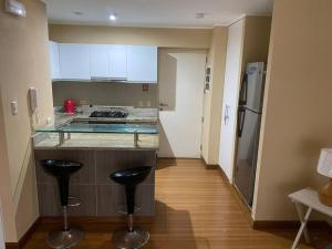 una cucina con bancone e due sgabelli in una stanza di Acogedor Departamento de un cuarto en Barranco... a Lima