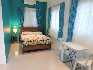 1 dormitorio con 1 cama, mesa y sillas en Alona WhiteHouses Resort en Panglao City