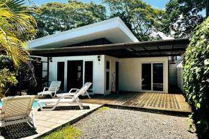 a small house with two chairs on a patio at Lapa House 4 ( Cozy pool-3 bedrooms(LL#4) in Jacó