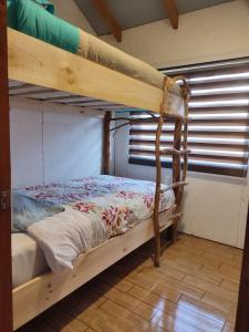Etagenbett in einem Zimmer mit Fenster in der Unterkunft Refugio Wanglen Cabañas y Tinajas hidromasaje in Lago Ranco