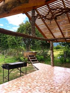 un pabellón con un banco bajo un techo de madera en Refugio Wanglen Cabañas y Tinajas hidromasaje, en Lago Ranco