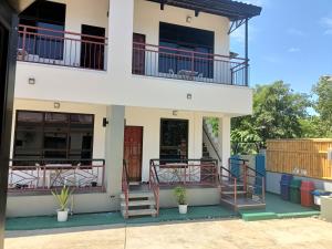 a house with balconies and stairs in front of it at Alona WhiteHouses Resort in Panglao