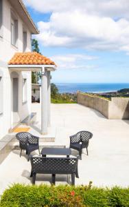 eine Terrasse mit Stühlen, einem Pavillon und Meerblick in der Unterkunft AG Casa Anema 10 huéspedes a 2km de la playa Razo in A Coruña