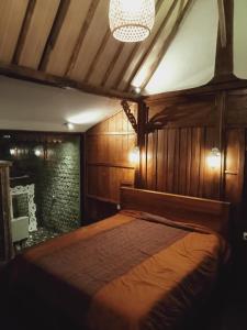 1 dormitorio con cama y lámpara de araña en Buratwangi Joglo House, en Kerobokan