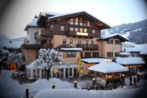 ein großes Gebäude im Schnee mit Leuten davor in der Unterkunft Appartements Lorenzoni, Cafe Konditorei Helmut Lorenzoni in Kirchberg in Tirol