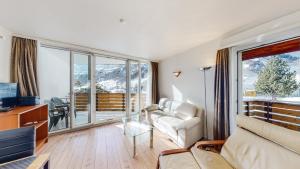 Il comprend un salon avec un canapé, une télévision et un balcon. dans l'établissement Matterhof, à Loèche-les-Bains