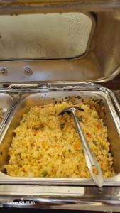 a pan of rice with a spoon in it at Sao Việt HTH Hotel in Ha Long