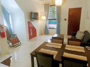 a living room with a table and chairs and a couch at Alona WhiteHouses Resort in Panglao Island