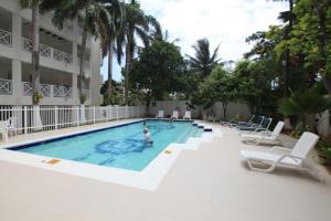 een persoon die zwemt in een zwembad met stoelen bij Edificio Bay Point Apto 402 Punta Hansa in San Andrés