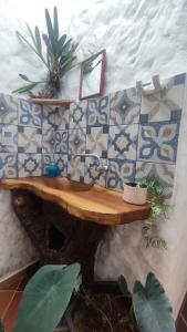 y baño con mesa de madera y pared de azulejos. en Selvatica EcoHostal, en San Carlos
