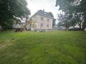 a large yard with a large house with a fence at Retreat near Beaches in Gloucester