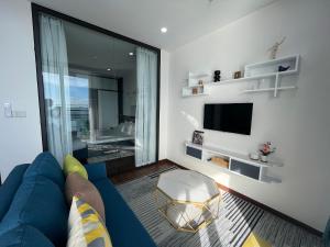 ein Wohnzimmer mit einem blauen Sofa und einem TV in der Unterkunft 2S Homestay in Hạ Long