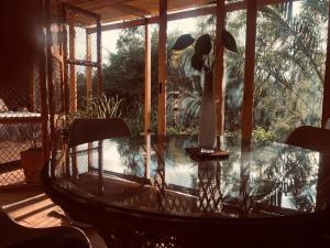 einen Glastisch mit Stühlen auf einer Terrasse mit Pool in der Unterkunft Cozy and isolated with hot springs in Quito