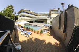 una piscina con sillas y sombrillas junto a un edificio en Hotel Estrella Norte, en Isla