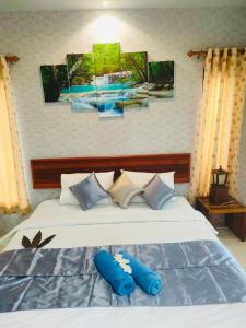 a bedroom with a bed with blue pillows on it at Andawa Lanta Resort in Ko Lanta