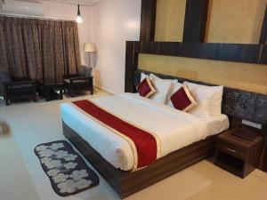 1 dormitorio con 1 cama grande en una habitación en Aarunya Hotel And Resort, en Rajgir