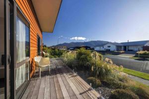 a porch of a house with two chairs and a window at New Studio in Te Anau