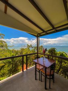 a table on a balcony with a view of the ocean at La Uvita Perdida in Uvita