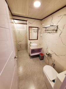 a bathroom with a toilet and a sink at Sun & Surf in Thulusdhoo +66 photos