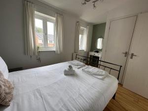 a white bed in a bedroom with a window at Manchester 2 Bedroom House with Garden in Manchester