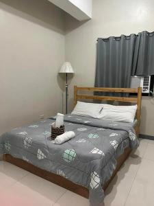1 dormitorio con 1 cama con edredón gris en P3K Suites Budget Hotel en Manila