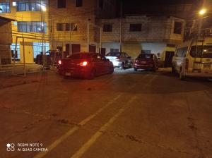 un grupo de autos estacionados en un estacionamiento por la noche en Casa Alojamiento Virreynal en San Ramón