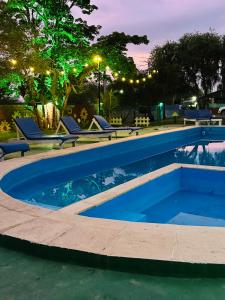 a swimming pool at night with lounge chairs around it at Cabañas Mirador del Dique in Termas de Río Hondo