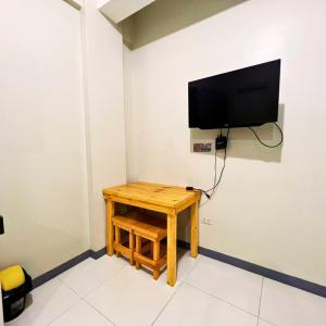 Habitación con mesa y TV en la pared. en P3K Suites Budget Hotel en Manila