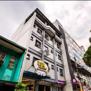 un edificio blanco con un letrero amarillo. en P3K Suites Budget Hotel en Manila