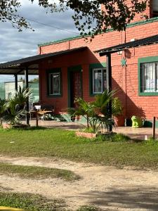 Casa de ladrillo rojo con mesa y patio en Cabañas Mirador del Dique en Termas de Río Hondo