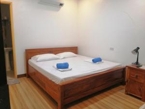 1 dormitorio con 1 cama con 2 almohadas azules en Baki Divers and Beach Resort, en Dauin