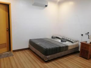 1 dormitorio con 1 cama en una pared blanca en Baki Divers and Beach Resort, en Dauin