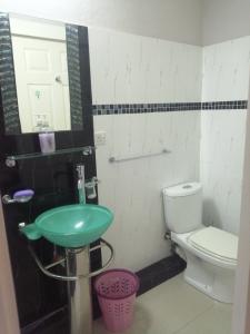 a bathroom with a green sink and a toilet at Coral Park Appt D1 in Rivière du Rempart +8 photos