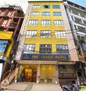 un edificio amarillo con un gran hotel en la calle en The Grand Hotel, en Āīzawl