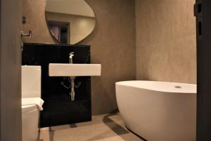 a bathroom with a sink and a toilet and a mirror at KSL ESPLANADE HOTEL with HOT SPRING in Klang