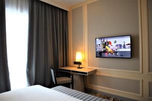 a hotel room with a bed and a tv on the wall at KSL ESPLANADE HOTEL with HOT SPRING in Klang