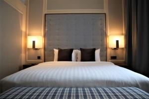 een slaapkamer met een groot wit bed met 2 lampen bij KSL ESPLANADE HOTEL with HOT SPRING in Klang