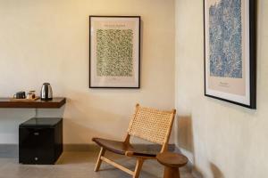 einen Stuhl in einem Zimmer mit zwei Bildern an der Wand in der Unterkunft Villa Olea in Uluwatu