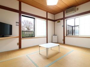 a room with a white table in a room with windows at 民宿 朝富士 in Yamanakako