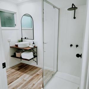 a bathroom with a glass shower and a sink at Eight Acres Lakes Entrance in Lakes Entrance