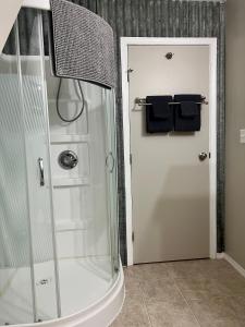 a bathroom with a shower with blue towels on a door at The Big Red Barn in Whitehorse